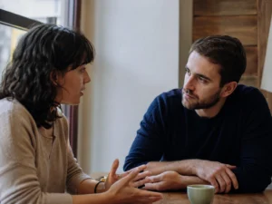 Two adults discussing a confusing personal situation with thoughtful and neutral body language